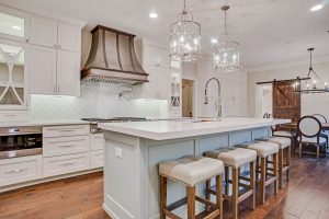 Brightly lit remodeled kitchen with island and stools